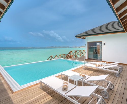 Private rectangular pool on the wooden deck of a Lagoon Residence at Joy Island Maldives with white sun loungers and open views of the turquoise lagoon under a blue sky