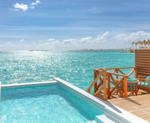 Private pool on the overwater deck of a Lagoon Suite at Joy Island Maldives with turquoise seating and open views of the sparkling turquoise lagoon under a clear blue sky