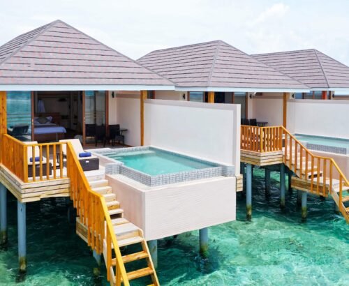 Ocean Pool Villas at Brennia Kottefaru Maldives standing on stilts above the clear turquoise lagoon with private pools, wooden decks, and stairs leading into the water