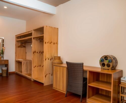 Practical wardrobe and desk area in a Two Bedroom Bougain Villa at Brennia Kottefaru Maldives featuring light wooden open storage, a desk with chair, and warm flooring