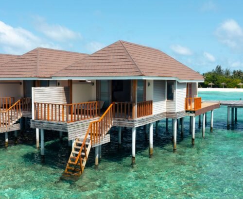 Overwater Water Villas at Brennia Kottefaru Maldives standing on stilts above the clear turquoise lagoon with wooden decks and stairs leading into the water