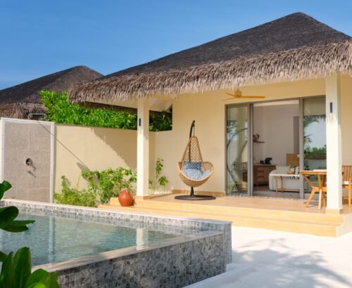 Private beach pool villa at dusitD2 Feydhoo Resort Maldives featuring a thatched roof, private swimming pool, outdoor hanging chair, open patio, outdoor shower, and tropical garden under clear blue skies – perfect for a Maldives tour package.