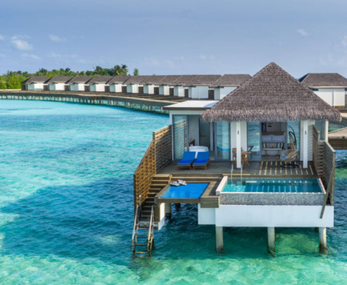 Overwater pool villa at dusitD2 Feydhoo Resort Maldives featuring a private swimming pool, wooden deck with blue sun loungers, hanging chair, thatched roof, and direct ladder access to the crystal-clear turquoise lagoon – perfect for a Maldives tour package.